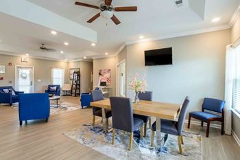 Dining room with a wooden table and blue chairs at Cedar Terrace Apartments in Hendersonville